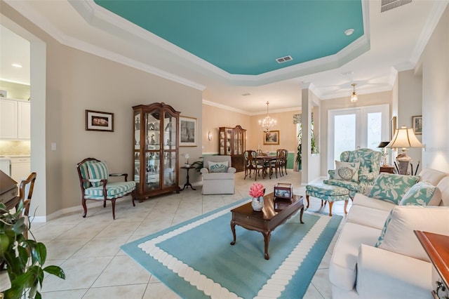 tiled living room with french doors, crown molding, a raised ceiling, and a chandelier