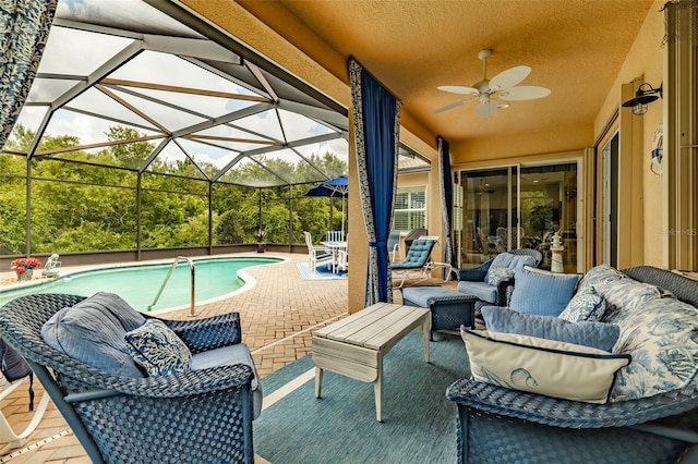 view of pool with a lanai, outdoor lounge area, a patio, and ceiling fan