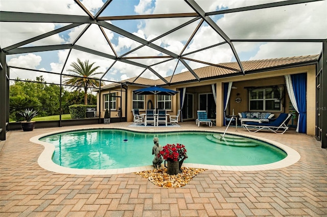 view of pool with a patio area and glass enclosure