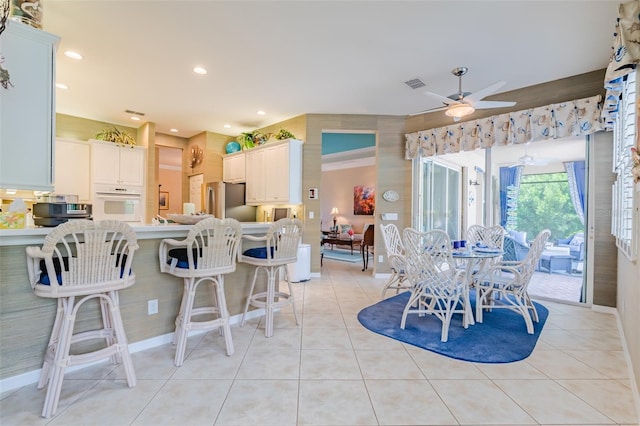 tiled dining area with ceiling fan