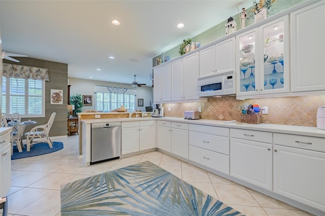 kitchen with ceiling fan, stainless steel dishwasher, kitchen peninsula, and white cabinets