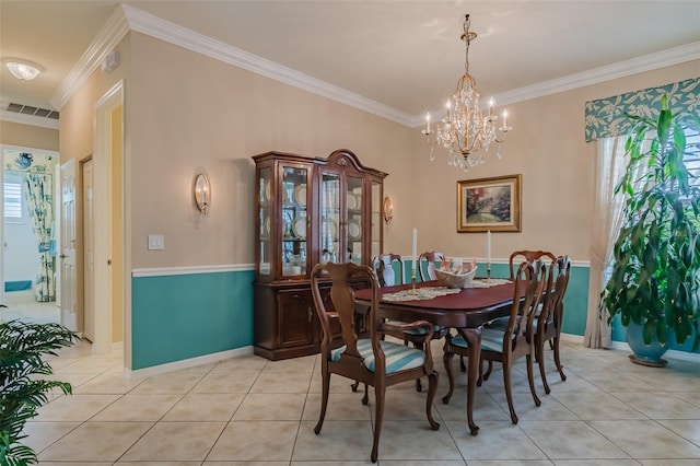 dining area with a notable chandelier, ornamental molding, and light tile patterned floors