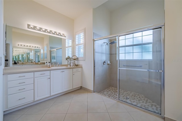 bathroom featuring vanity, a shower with shower door, and tile patterned floors