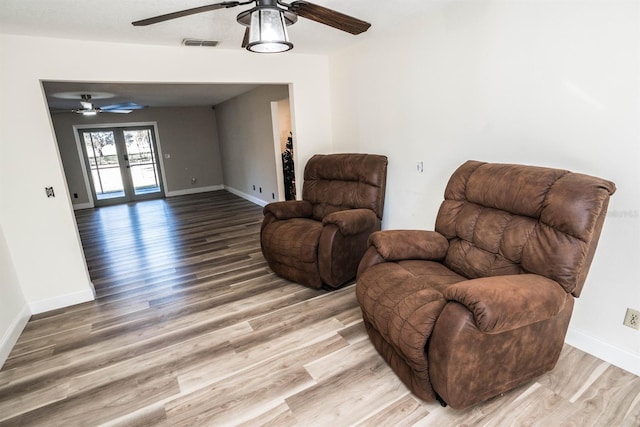 living area featuring ceiling fan, french doors, and hardwood / wood-style flooring