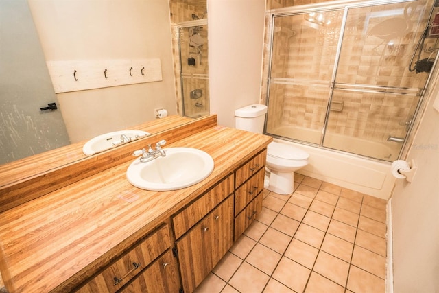 full bathroom with combined bath / shower with glass door, toilet, tile patterned flooring, and vanity