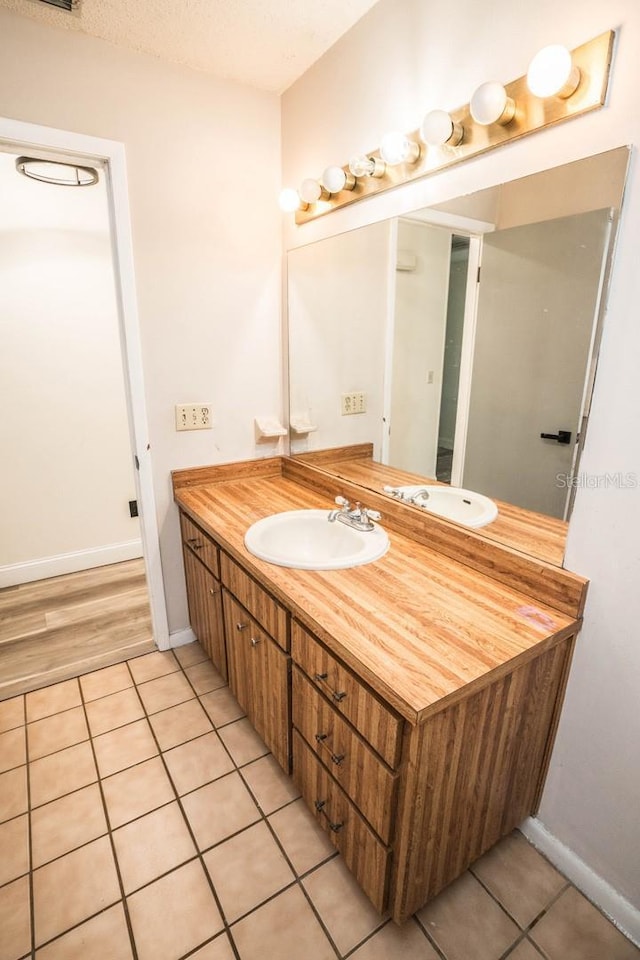 bathroom with a textured ceiling, vanity, and tile patterned flooring