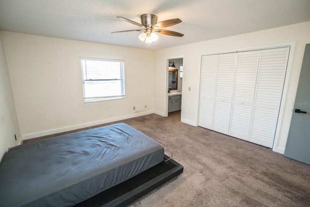 bedroom featuring ceiling fan, a textured ceiling, ensuite bathroom, and carpet floors