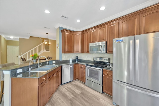 kitchen with sink, crown molding, appliances with stainless steel finishes, and kitchen peninsula