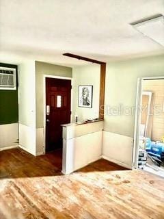 foyer featuring dark wood-type flooring and an AC wall unit