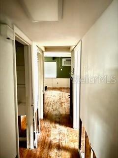 hallway featuring hardwood / wood-style flooring and a wall mounted AC