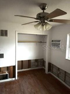 unfurnished bedroom featuring ceiling fan and dark hardwood / wood-style flooring