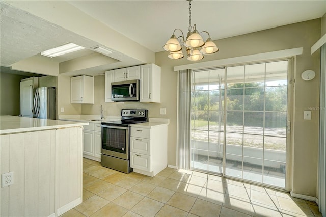 kitchen with hanging light fixtures, light tile patterned floors, white cabinets, an inviting chandelier, and stainless steel appliances