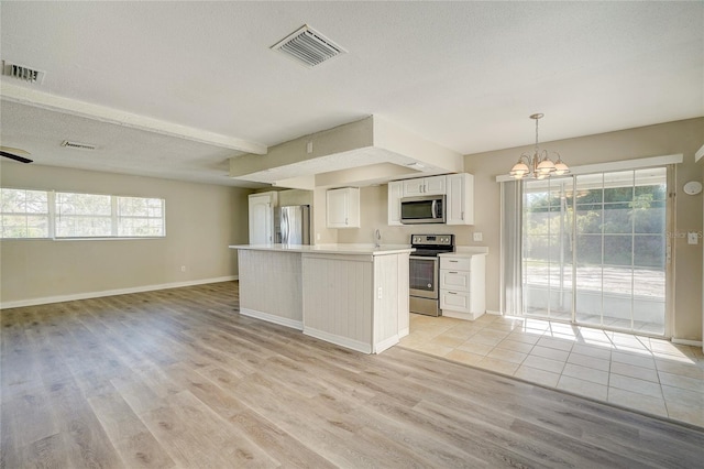 kitchen featuring light hardwood / wood-style floors, white cabinetry, pendant lighting, and appliances with stainless steel finishes