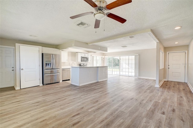 kitchen with appliances with stainless steel finishes, a textured ceiling, white cabinetry, light hardwood / wood-style flooring, and ceiling fan