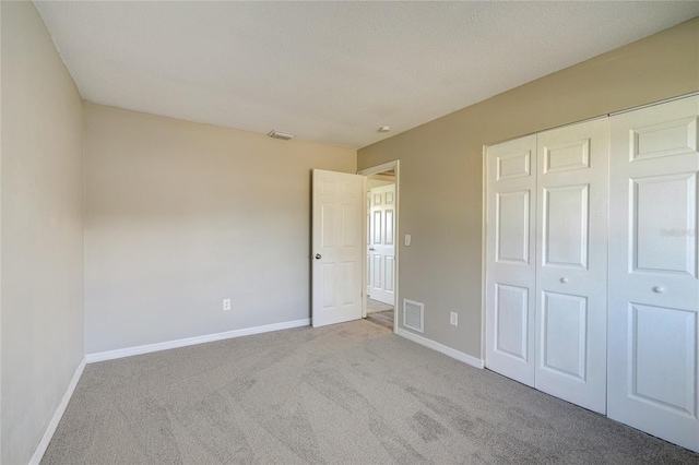 unfurnished bedroom featuring carpet flooring and a closet