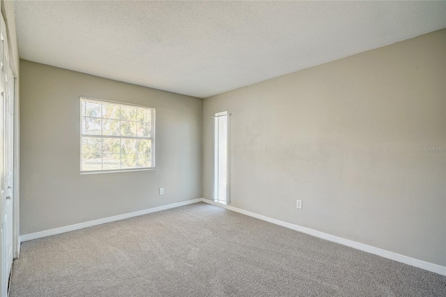 carpeted spare room featuring a textured ceiling