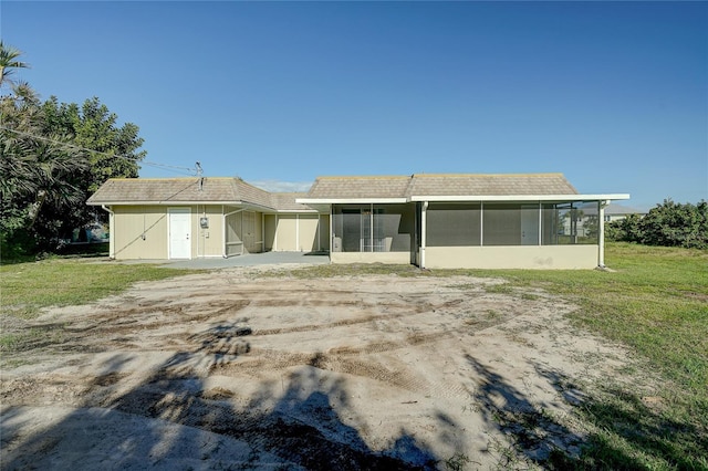 rear view of property with a sunroom and a lawn