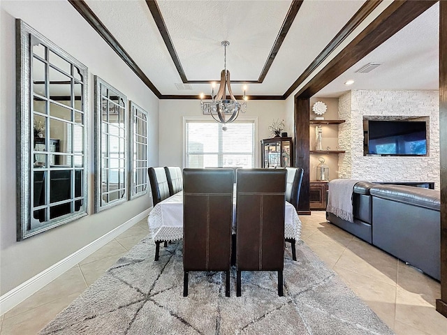 tiled dining space with ornamental molding, a chandelier, and a textured ceiling