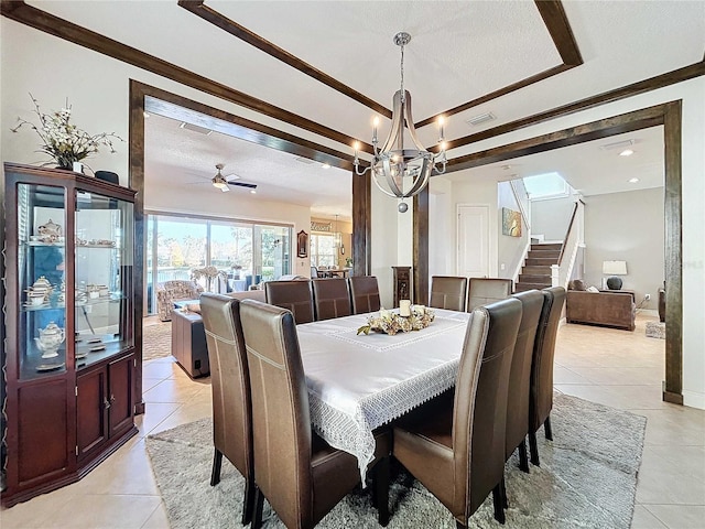 tiled dining space with a textured ceiling and a notable chandelier