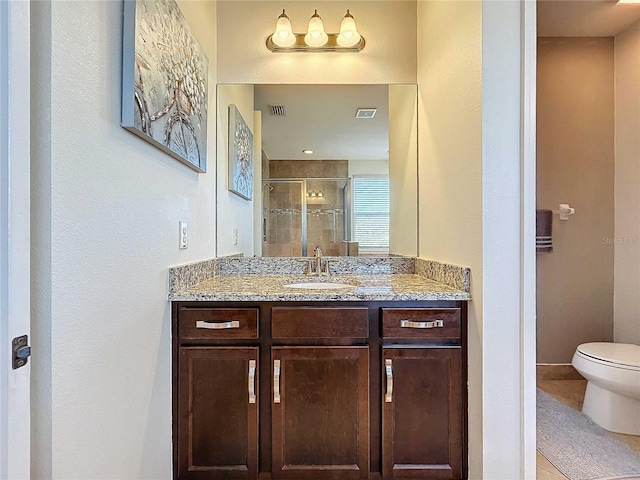 bathroom featuring vanity, tile patterned floors, toilet, and walk in shower