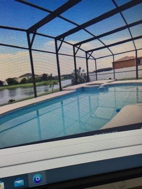 view of swimming pool featuring glass enclosure