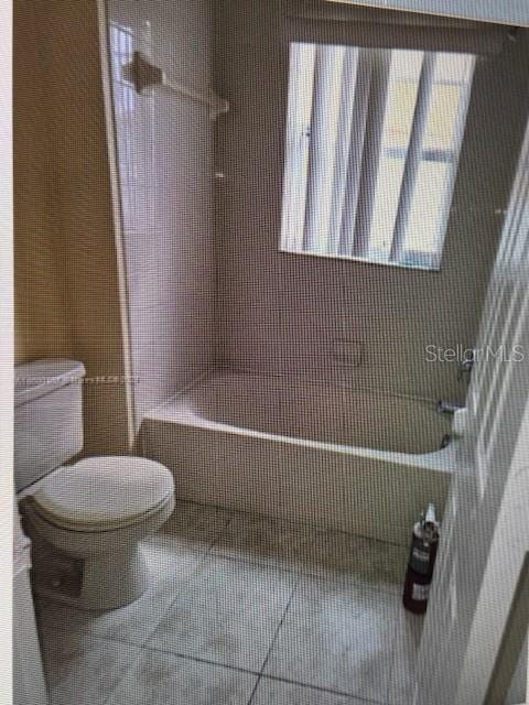 bathroom with toilet and tile patterned floors