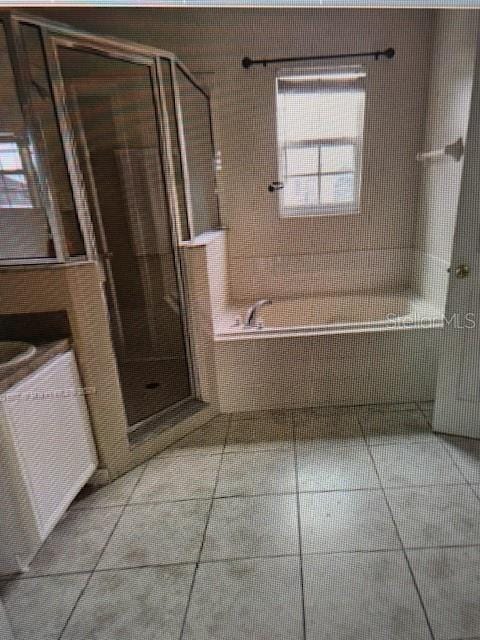 bathroom with a bath and tile patterned flooring