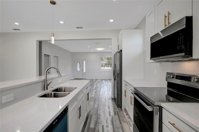 kitchen with stainless steel appliances, sink, hanging light fixtures, and white cabinets