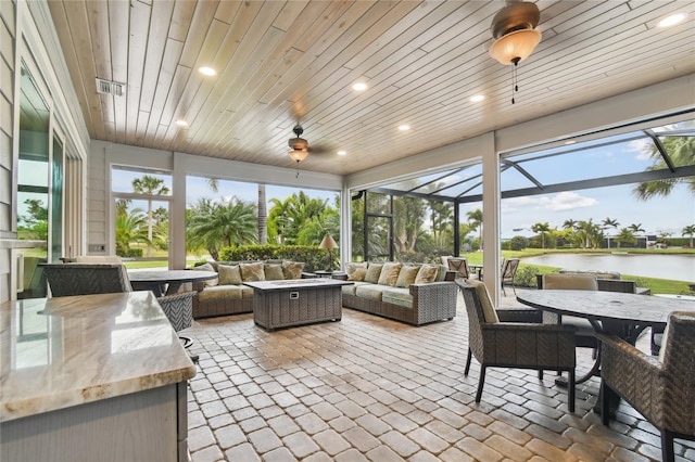 sunroom featuring wood ceiling and a water view