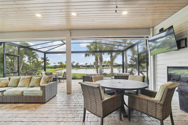 sunroom / solarium featuring wood ceiling and exterior fireplace