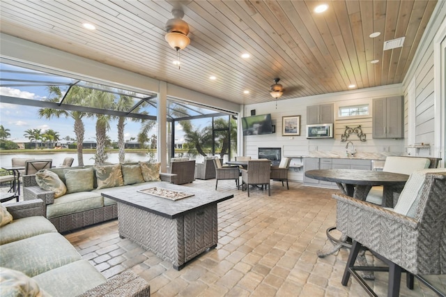 living room with wood ceiling, sink, and a water view