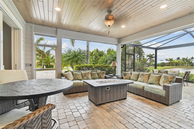 sunroom featuring ceiling fan and wood ceiling