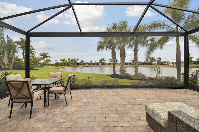 view of patio featuring glass enclosure and a water view