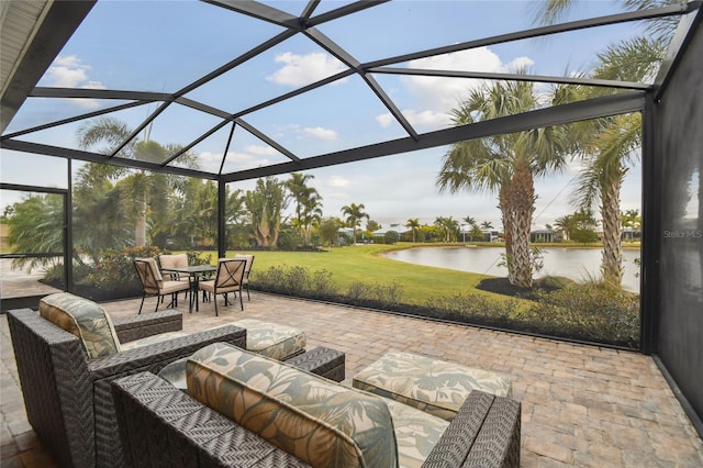 view of patio with glass enclosure and a water view