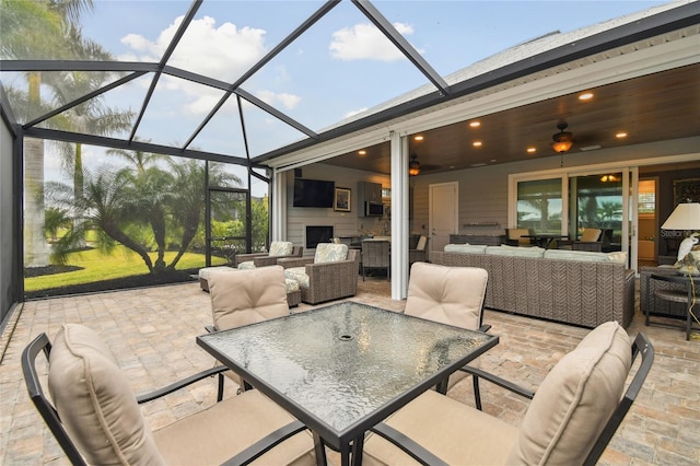 view of patio with glass enclosure, outdoor lounge area, and ceiling fan