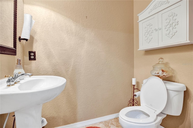 bathroom featuring sink, toilet, and tile patterned flooring