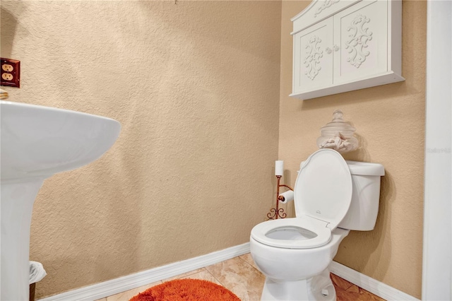 bathroom featuring toilet and tile patterned flooring