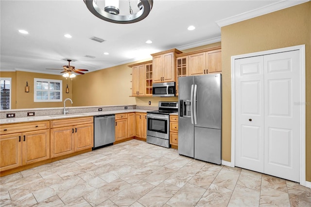 kitchen with sink, ornamental molding, ceiling fan, and appliances with stainless steel finishes