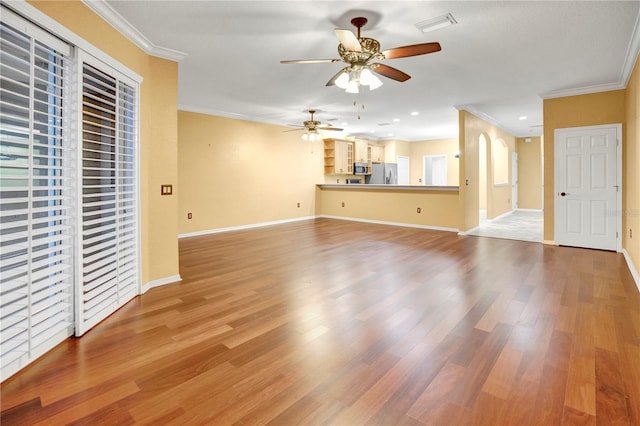 unfurnished living room featuring light wood-type flooring, ceiling fan, and ornamental molding