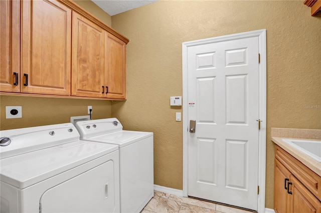 washroom with sink, separate washer and dryer, cabinets, and light tile patterned floors