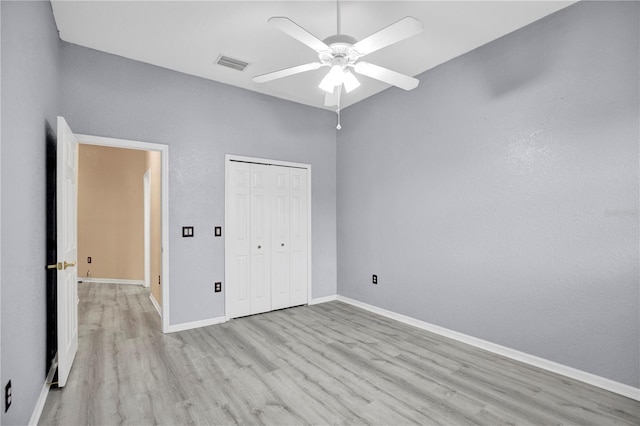 unfurnished bedroom featuring ceiling fan, a closet, and light hardwood / wood-style flooring