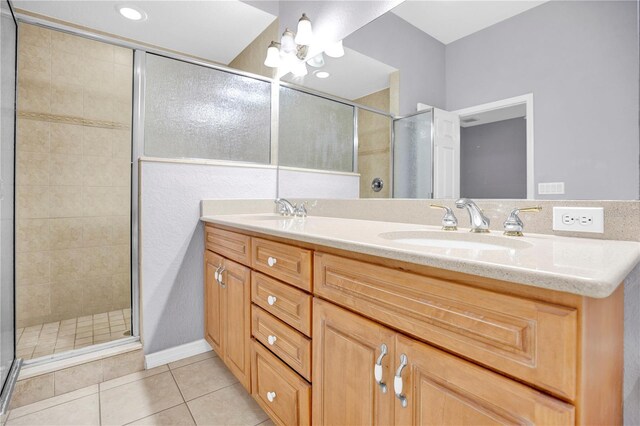 bathroom with a shower with shower door, tile patterned floors, and vanity