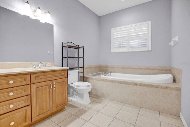 bathroom with vanity, toilet, tile patterned floors, and tiled bath