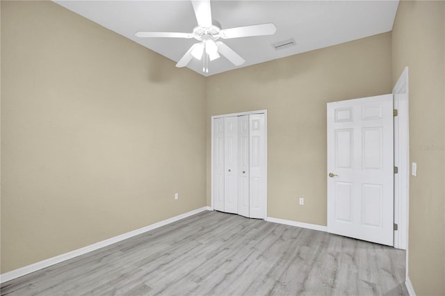 unfurnished bedroom with ceiling fan, a closet, and light wood-type flooring