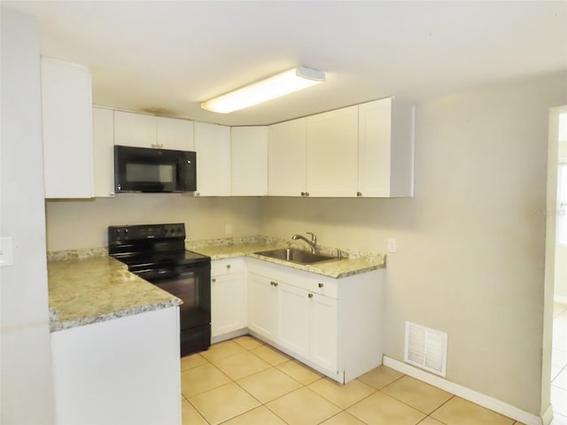 kitchen featuring sink, light tile patterned floors, white cabinets, and black appliances