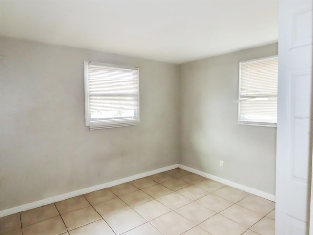 spare room featuring plenty of natural light and light tile patterned floors