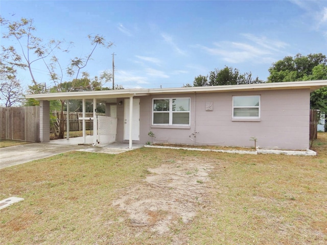 ranch-style home featuring a carport and a front lawn