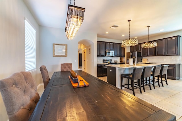 dining space featuring light tile patterned flooring and an inviting chandelier