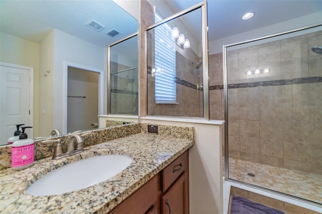 bathroom featuring an enclosed shower and vanity