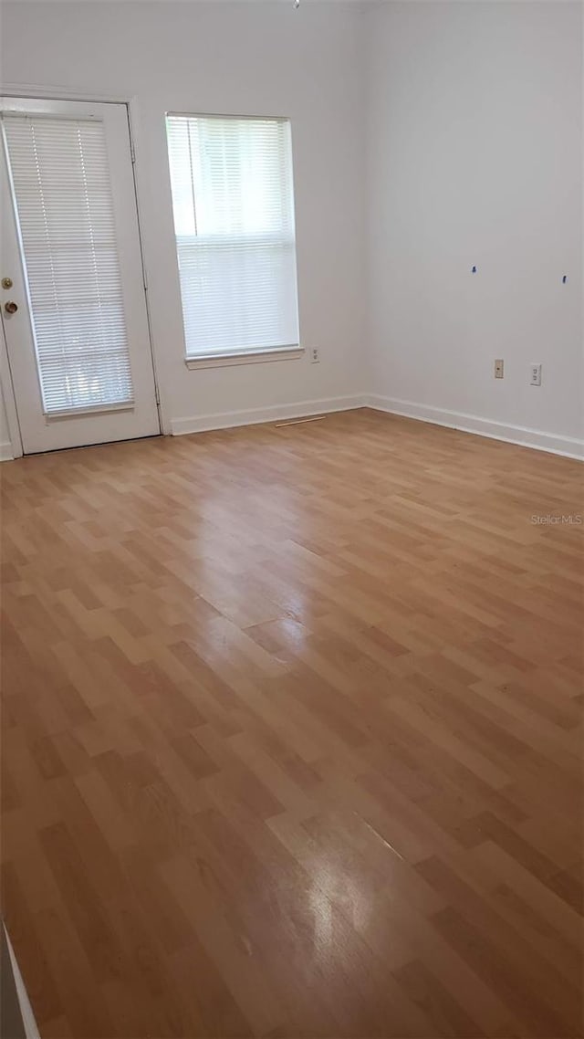 empty room with light hardwood / wood-style flooring